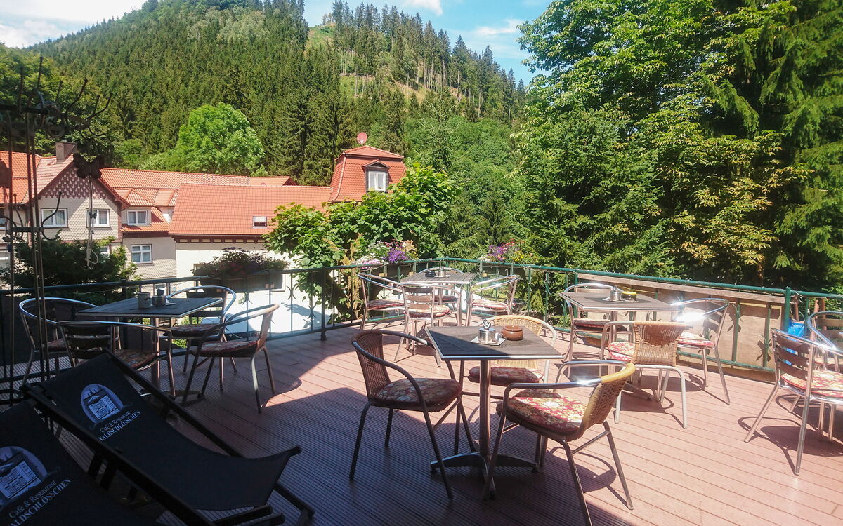 Die bestuhlte Terrasse von der Pension Café Waldschlösschen mit Blick auf den Thüringer Wald in Friedrichroda