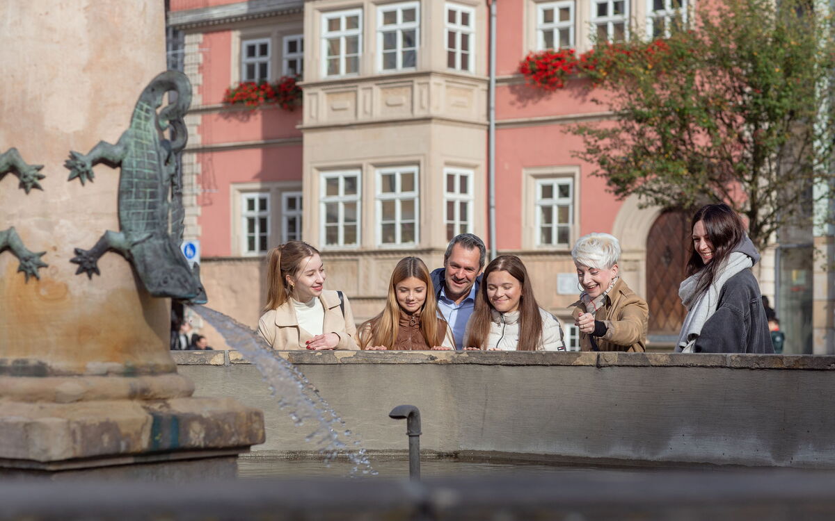 Eine Familie am Marktbrunnen in Eisenach während einer Stadtführung