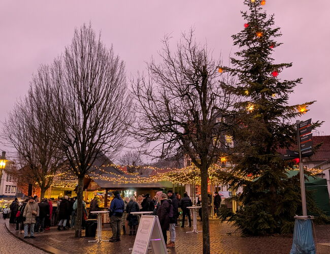 erleuchteter Kirchplatz mit St&auml;nden und Menschen